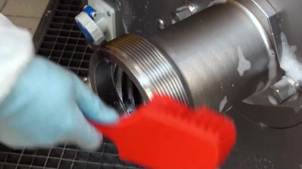 Mão na luva com escova de espuma vermelha limpa lava aço moedor de carne industrial . — Vídeo de Stock
