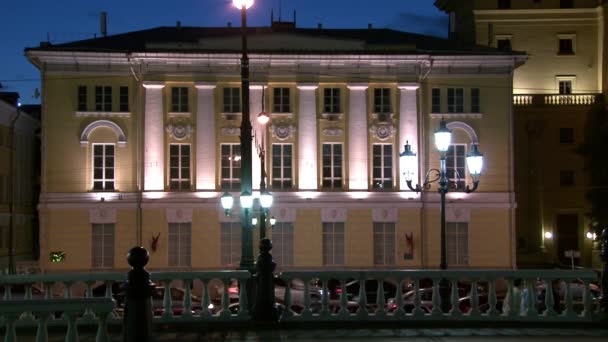 Coches conducir a lo largo de la carretera cerca de la hermosa arquitectura de Moscú por la noche . — Vídeos de Stock