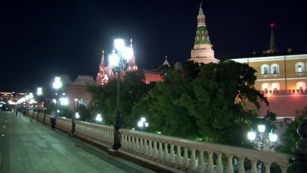 Mensen lopen op de brug in de buurt van Kremlin op het Rode plein in Moskou in de nacht. — Stockvideo