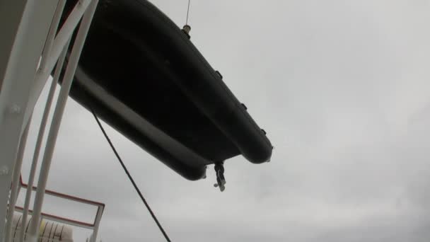 Gumový člun sestupuje do vodní hladiny oceánu Antarktidy. — Stock video