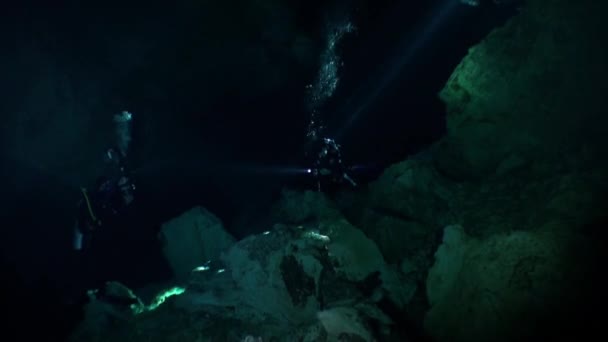 Swimming with flashlight in dark caves of Yucatan cenotes underwater in Mexico. — Stock Video