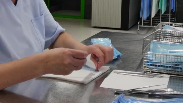 Женщины заворачивают салфетки и кладут медицинские инструменты в коробку . — стоковое видео