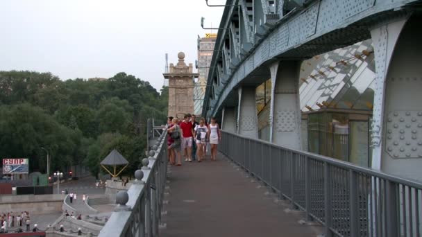 Ludzie na Pushkinsky Andreyevsky mostu nad rzeką. — Wideo stockowe