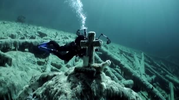 Potápěč filmaře poblíž hrobu s cross underwaterin Tyrolsko jezero Fernsteinsee. — Stock video