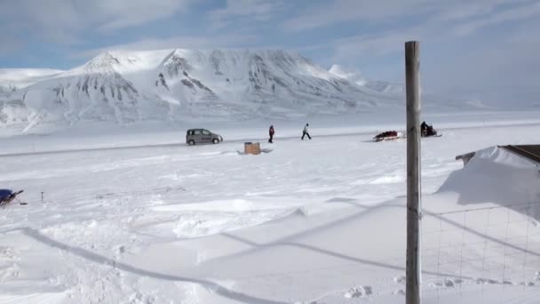 Człowiek u podstawy psich zaprzęgów zespołu husky eskimo na biegun północny w Arktyce. — Wideo stockowe