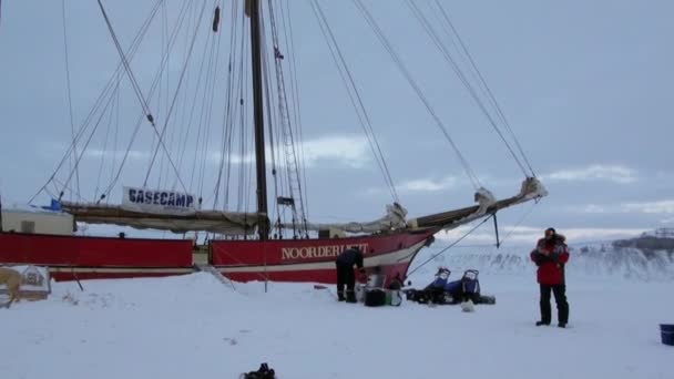 Equipo de trineo para perros husky eskimo cerca de velero Noorderlicht en el Ártico . — Vídeo de stock