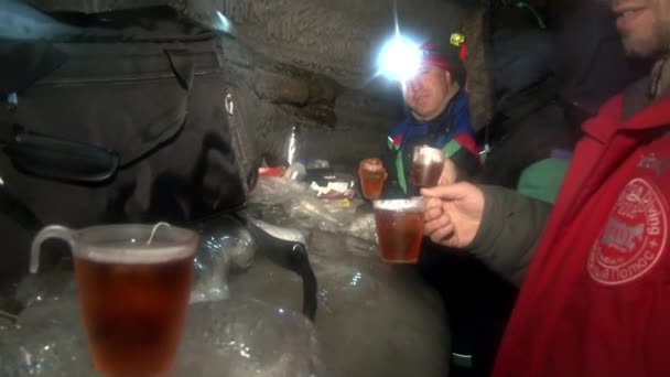 Mensen drinken warme thee in een ijsgrot koud in Noordpoolgebied Svalbard. — Stockvideo
