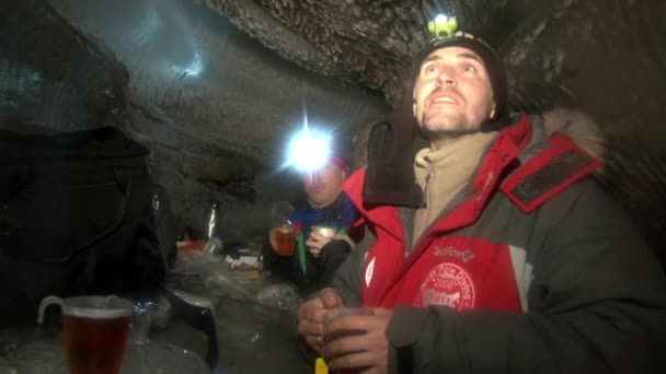 Lidé pít horký čaj v chladné ledová jeskyně v Arktidě Špicberky. — Stock video
