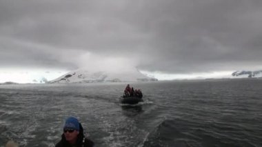 İnsanlar kauçuk boatt buz Antarktika okyanus su yüzeyi.