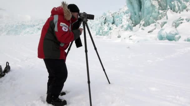 Hombre fotógrafo en el hermoso glaciar turquesa único en el Ártico . — Vídeos de Stock