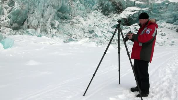 Man fotograaf op prachtige unieke turquoise gletsjer in Noordpoolgebied. — Stockvideo