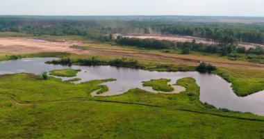 Eğimli quadcopter orman üzerinde uçan üzerinden nehir havadan görünümü.