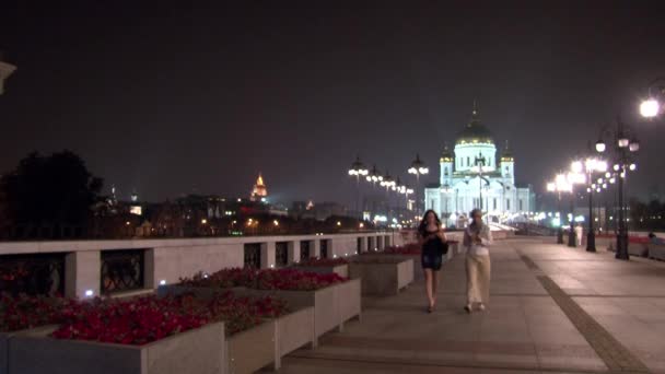 Zwei Mädchen gehen nachts auf patriarchalischer Brücke zur Kathedrale des Erlösers Christi. — Stockvideo