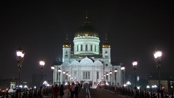 Mensen lopen langs patriarchaal brug naar de kathedraal van Christus Verlosser in Moskou. — Stockvideo