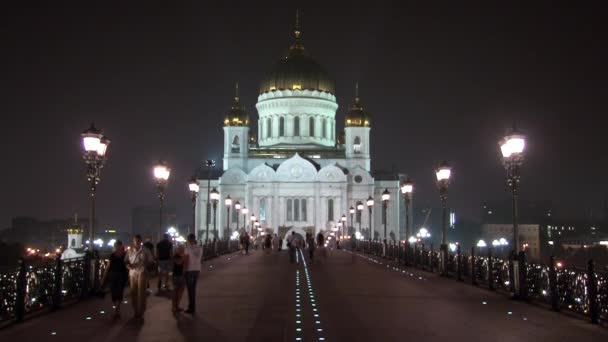 La gente camina a lo largo del puente patriarcal a la Catedral de Cristo Salvador en Moscú . — Vídeos de Stock