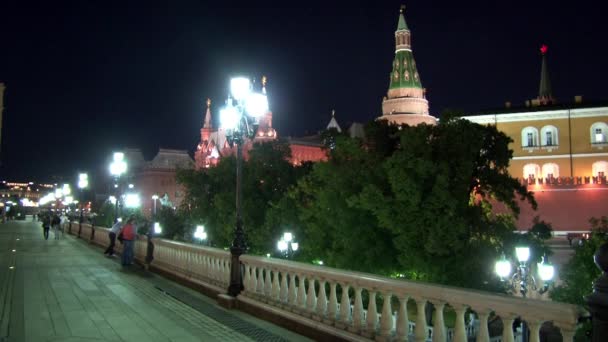 Mensen lopen op de brug in de buurt van Kremlin op het Rode plein in Moskou in de nacht. — Stockvideo