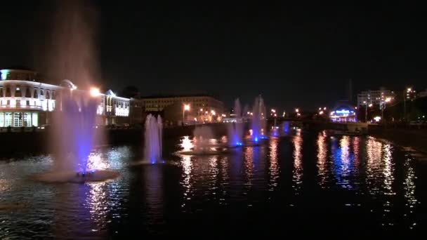 Glowing fountains in river and lanterns on bridge background in Moscow at night. — Stock Video