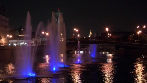 Glowing fountains in river and lanterns on bridge background in Moscow at night. — Stock Video