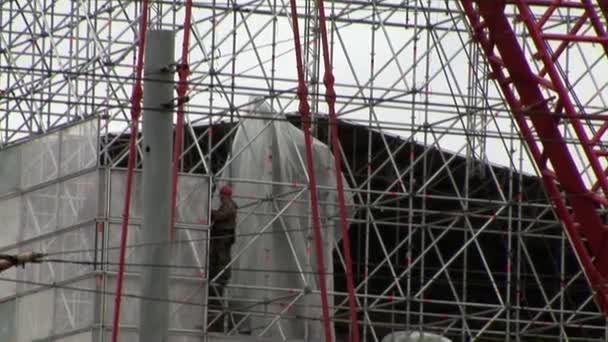 Gente trabajando en los andamios metálicos de los constructores . — Vídeo de stock