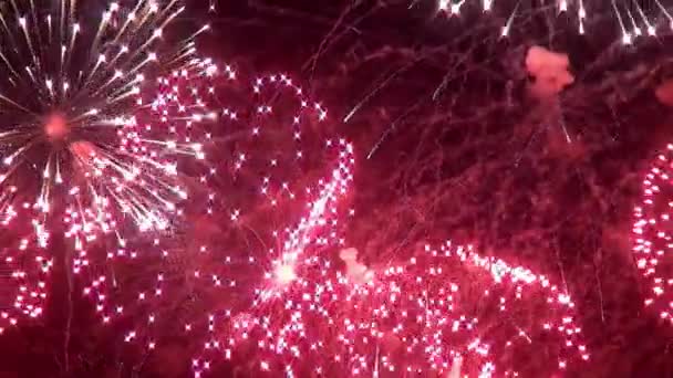 Explosiones amarillas verdes rojas brillantes de la exhibición de fuegos artificiales sobre fondo negro . — Vídeos de Stock