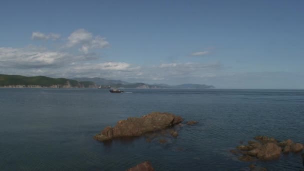 Havet vågor vatten ytan på gröna steniga klippor kust strand i Japan havet. — Stockvideo