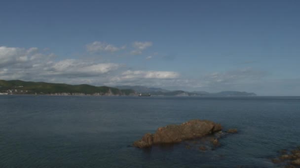 바다 파도 물 일본 바다에서 녹색 돌 바위 해안선에 표면. — 비디오