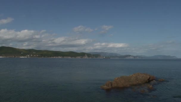 Vagues de mer surface de l'eau sur des roches vertes rocheuses plage littorale au Japon Mer . — Video