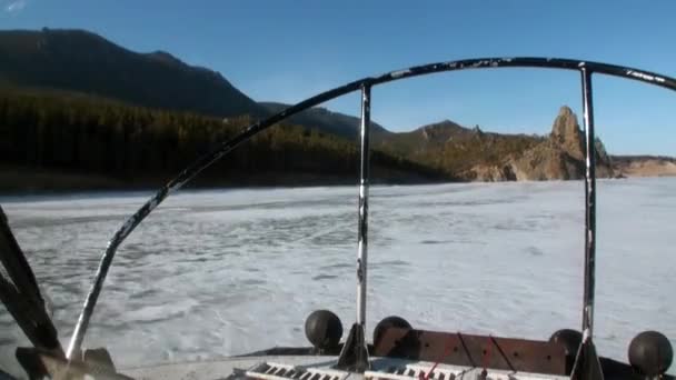 Vzducholoď se pohybuje na horském pobřeží na ledě jezera Bajkal. — Stock video