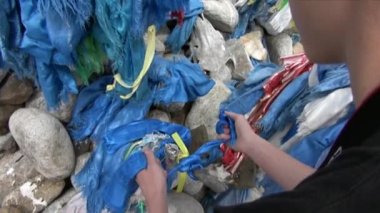 Çocuk, Moğolistan 'da şaman Obo' nun kurban ettiği taşlara mavi kurdele bağlıyor..
