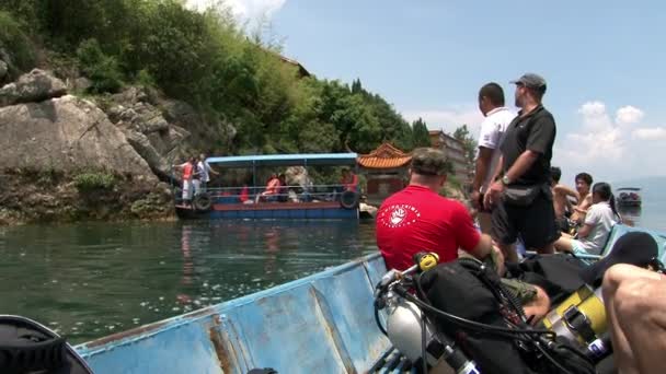 Dykare simmar på en båt till dykplatsen i Fuxian Lake. — Stockvideo