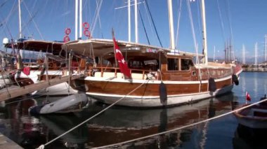 Lüks yatlar, Türkiye 'nin limanındaki mavi gökyüzünün arka planında sessizce duruyor.
