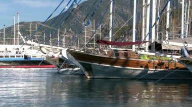 Lüks yatlar, Türkiye 'nin limanındaki mavi gökyüzünün arka planında sessizce duruyor.