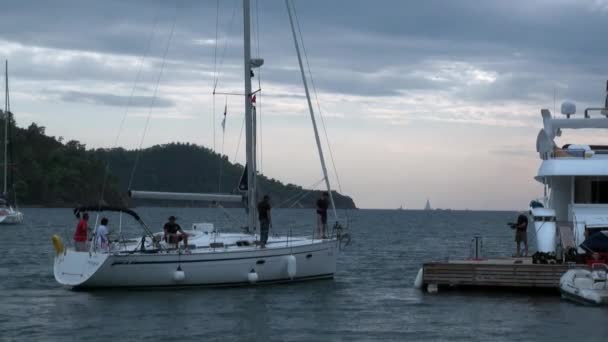 Weiße Yachten mit Menschen schwimmen in der Bucht. — Stockvideo