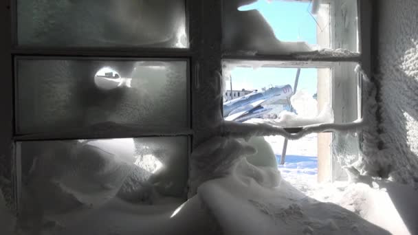 Eingefrorene Fenster und verschneite Zimmer in zerstörtem Haus in verlassener Stadt. — Stockvideo