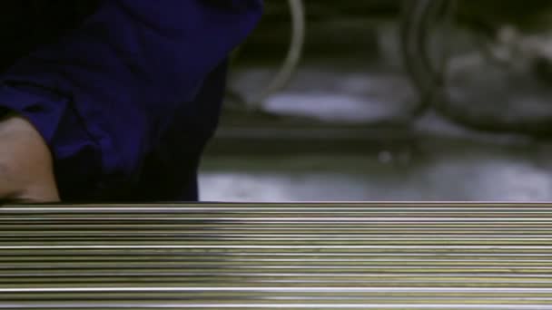 A háttérben a rozsdamentes acél csövek gyárban dolgozik a keze. — Stock videók