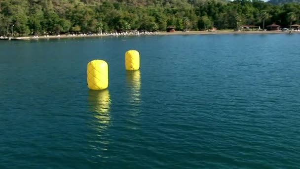 Boyas amarillas en la superficie del agua vista desde un yate de vela en movimiento  . — Vídeos de Stock