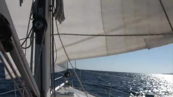 Velas blancas revoloteando en el viento de yate de vela en movimiento . — Vídeo de stock