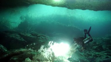 Yucatan Meksika 'nın sualtı mağaralarındaki kayalıklarda dalgıçlar.