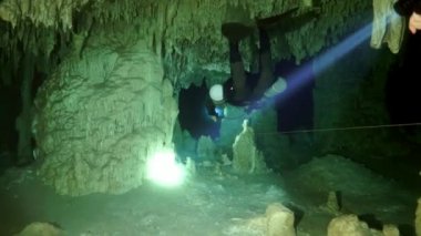 Yucatan Meksika 'nın sualtı mağaralarındaki kayalıklarda dalgıçlar.