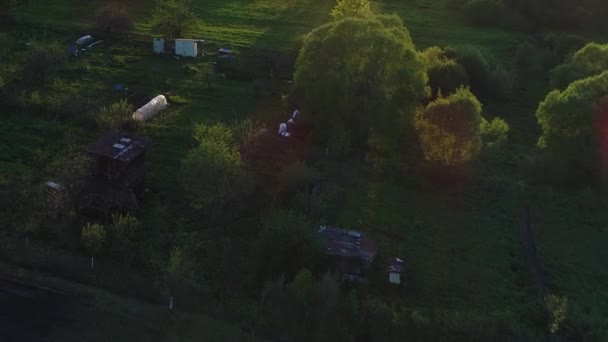 Panorama de ambiente selvagem de hamlet com casas e jardins em um rio cercado por pastos verdes com vistas deslumbrantes da paisagem cinematográfica. Conceito clima natureza exterior . — Vídeo de Stock
