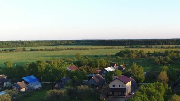 Дивовижна відеопанорама села з будинками і садами на річці, оточена зеленими пасовищами з приголомшливими краєвидами кіно. Концепція клімату зовнішньої природи . — стокове відео