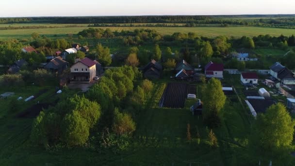 Een overhead shot wildernis gebied panorama van het platteland met huizen en tuinen aan een rivier omgeven door groen veld met een prachtig landschap filmische uitzichten. Concept klimaat buiten natuur. — Stockvideo