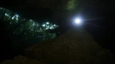 Yucatan Meksika 'nın sualtı mağaralarındaki kayalıklarda dalgıçlar.