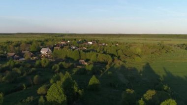 Köy 'ün, yoğun yeşil ormanlarla çevrili, büyüleyici manzaralı evleri ve bahçeleri olan insansız hava aracı video panoraması. Açık hava iklimi kavramı.