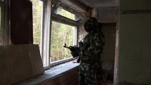 Airsoft player is in position is in a destroyed house. — Stock Video