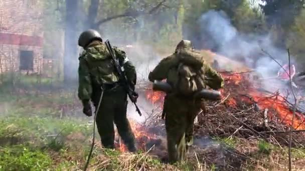 Hombres con uniformes militares apagan un incendio en el bosque . — Vídeo de stock