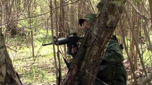 Hommes en uniformes militaires jouant sur airsoft polygone militaire dans la forêt . — Video