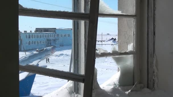 Schnee im zerbrochenen Fenster eines verlassenen Hauses in einer verlassenen Stadt. — Stockvideo