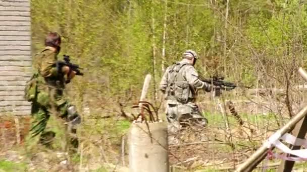 Hombres con uniformes militares jugando en la construcción en ruinas de polígono militar airsoft . — Vídeos de Stock