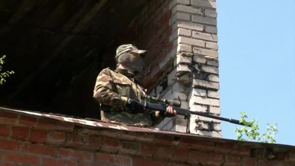 軍の制服を着た男が軍の多角形の破壊された建物で遊ぶ. — ストック動画